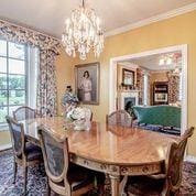 208 E Livingston St, San Augustine, TX 75972 - dining area with a chandelier, plenty of natural light, ornamental molding, baseboards, and a fireplace