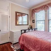 208 E Livingston St, San Augustine, TX 75972 - bedroom with crown molding, dark wood-style flooring, and ceiling fan