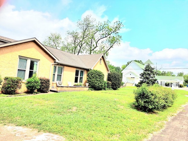 208 E Livingston St, San Augustine, TX 75972 - view of home's exterior featuring a yard and stucco siding