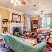 208 E Livingston St, San Augustine, TX 75972 - living area with healthy amount of natural light, a fireplace, and a ceiling fan