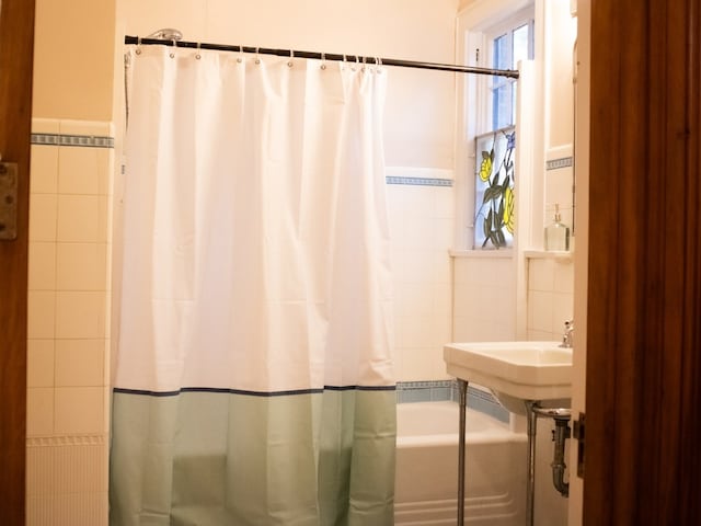 476 Jefferson Ave, Lufkin, TX 75904 - bathroom with tile walls and shower / bath combination with curtain
