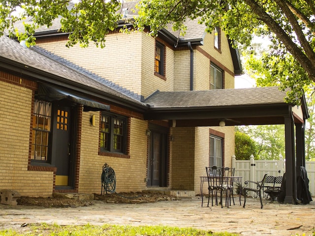 476 Jefferson Ave, Lufkin, TX 75904 - back of house featuring brick siding, fence, roof with shingles, and a patio area