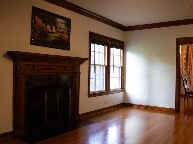 476 Jefferson Ave, Lufkin, TX 75904 - unfurnished living room with wood finished floors, ornamental molding, baseboards, and a tile fireplace