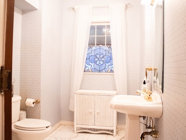 476 Jefferson Ave, Lufkin, TX 75904 - half bathroom with toilet, marble look tiles, and wallpapered walls