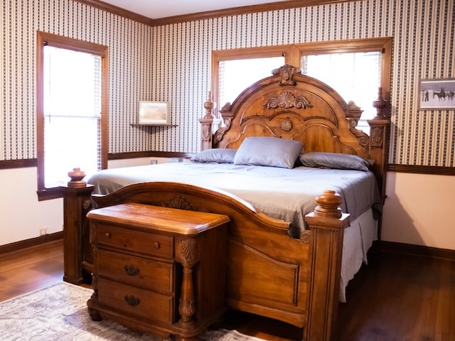 476 Jefferson Ave, Lufkin, TX 75904 - bedroom with baseboards, wood finished floors, multiple windows, ornamental molding, and wallpapered walls