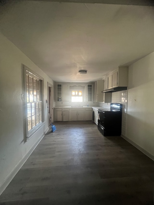 kitchen with electric range, dark wood-type flooring, white cabinets, and tasteful backsplash