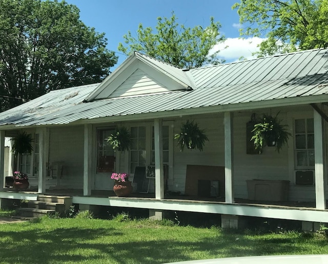 rear view of property with a lawn and covered porch