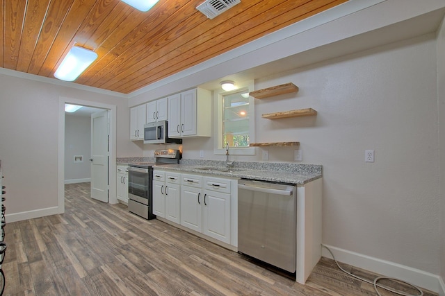 kitchen with visible vents, wood finished floors, stainless steel appliances, white cabinetry, and a sink