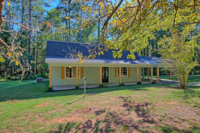 view of front facade featuring central air condition unit, a shingled roof, a porch, and a front lawn