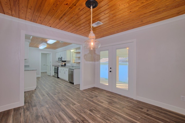 interior space with stainless steel appliances, french doors, white cabinetry, and dark wood finished floors