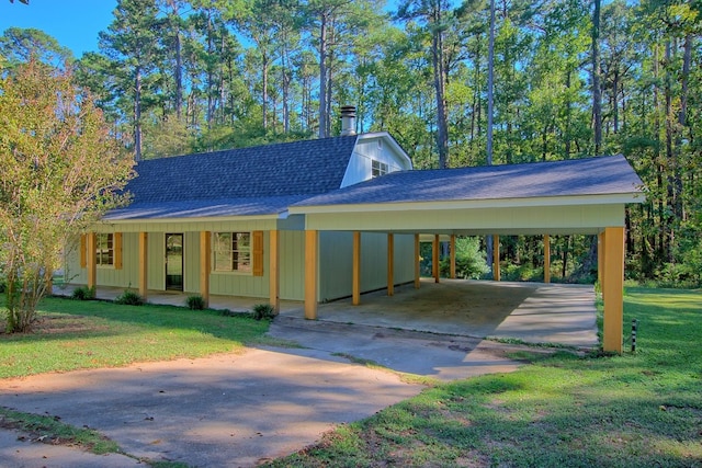 view of front facade featuring roof with shingles, a gambrel roof, a carport, driveway, and a front lawn