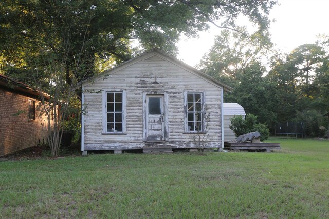 view of front of home with a front lawn and a trampoline