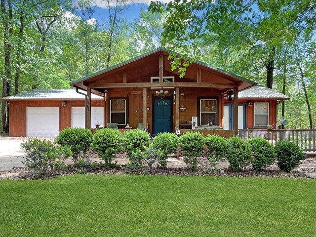 view of front of property with an attached garage, driveway, a front lawn, and covered porch