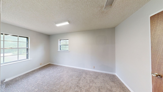 carpeted spare room featuring a textured ceiling