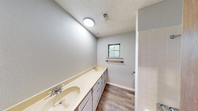 bathroom featuring vanity, wood-type flooring, and a textured ceiling