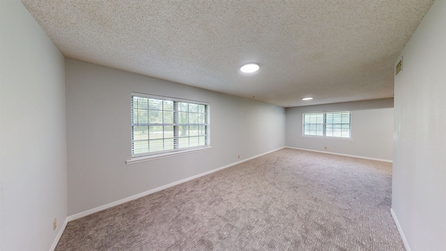 spare room with carpet floors and a textured ceiling