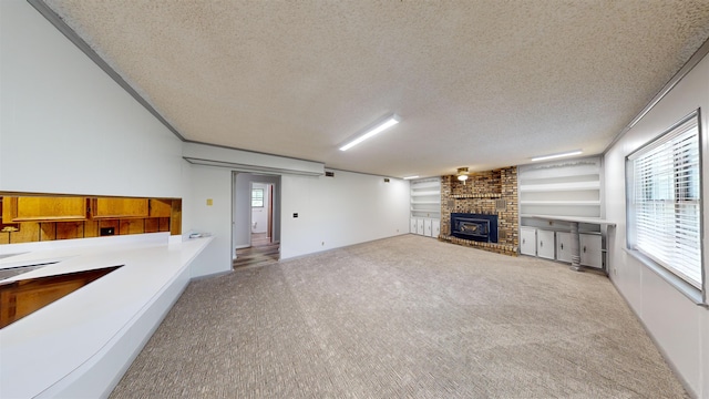 unfurnished living room featuring light carpet, a textured ceiling, and a brick fireplace