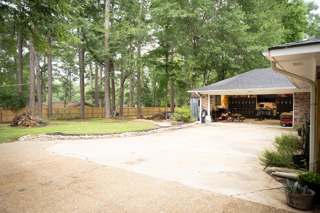 157 Craig St, Jasper, TX 75951 - view of patio with a garage, concrete driveway, and view of wooded area