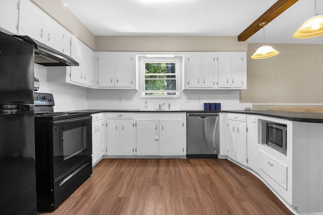 kitchen with white cabinetry, a peninsula, under cabinet range hood, dark countertops, and black appliances