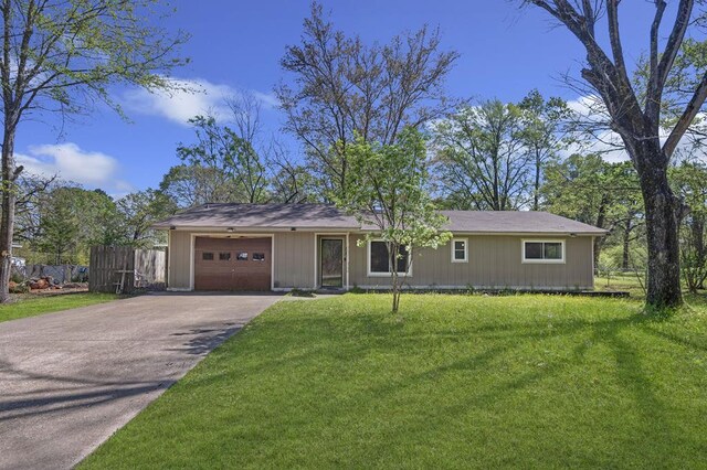 ranch-style house featuring driveway, a garage, a front lawn, and fence