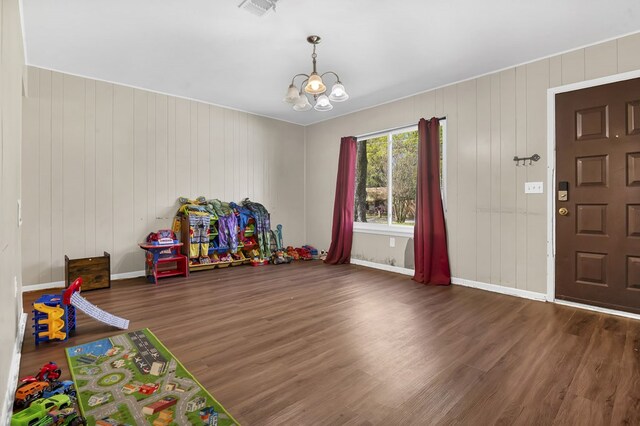 recreation room with baseboards, visible vents, wood finished floors, and a chandelier