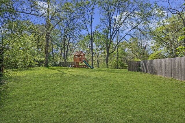 view of yard with a fenced backyard and a playground
