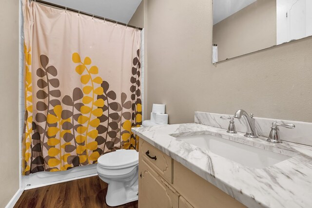 full bath with toilet, wood finished floors, vanity, and a shower with curtain