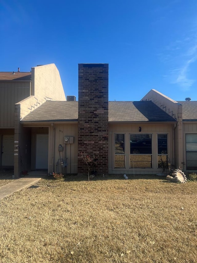 back of house with a garage and a yard