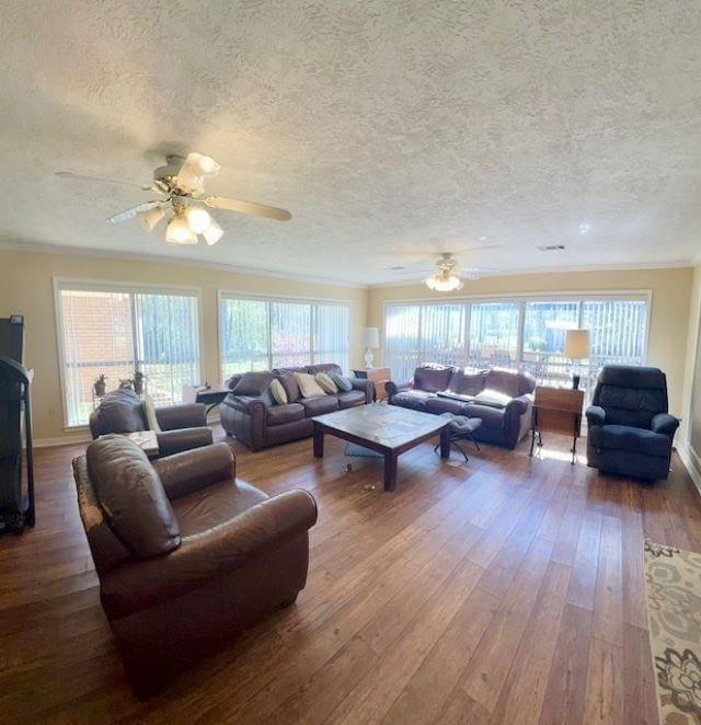 living room with ceiling fan, wood-type flooring, a textured ceiling, and ornamental molding