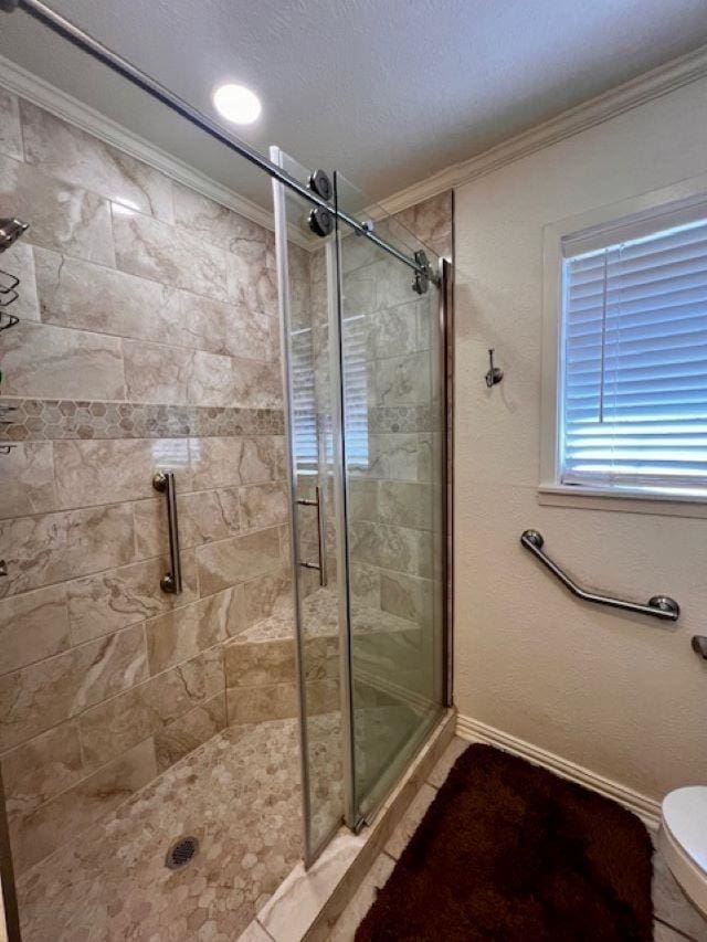 bathroom with a shower with shower door, toilet, ornamental molding, and a textured ceiling