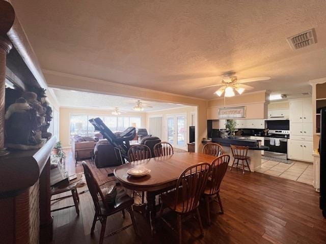 dining room with a textured ceiling, light wood-type flooring, a wealth of natural light, and ceiling fan