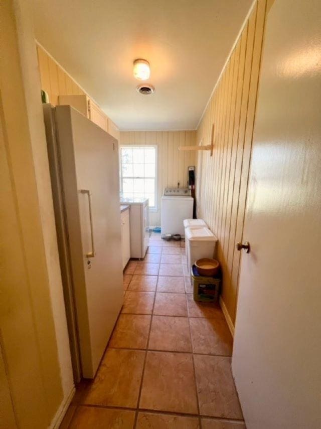 hall with washer / dryer and light tile patterned flooring