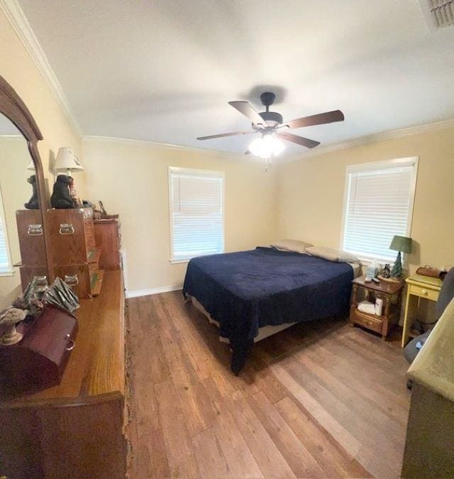 bedroom with multiple windows, ceiling fan, ornamental molding, and hardwood / wood-style flooring