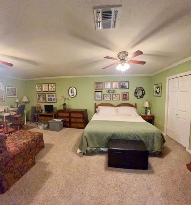 carpeted bedroom featuring a textured ceiling, a closet, ceiling fan, and crown molding