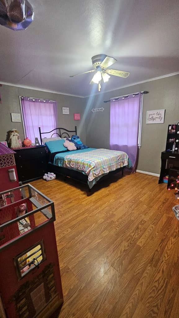 bedroom featuring ceiling fan, crown molding, and hardwood / wood-style floors