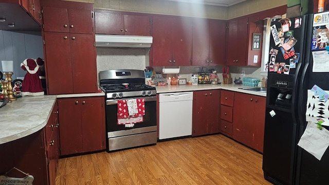 kitchen featuring light hardwood / wood-style floors, stainless steel gas range, dishwasher, and black fridge with ice dispenser