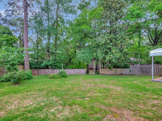 view of yard featuring a fenced backyard, an outbuilding, and a shed