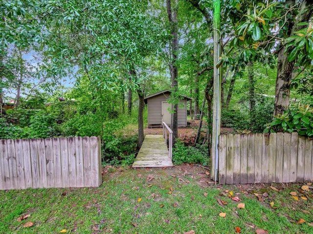 view of yard with fence, an outbuilding, and a shed