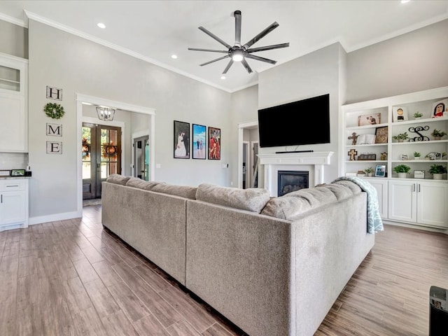 387 Cc Rd, Diboll, TX 75941 - living room with a glass covered fireplace, ceiling fan, crown molding, light wood-style flooring, and french doors