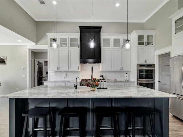 387 Cc Rd, Diboll, TX 75941 - kitchen with stainless steel appliances, crown molding, tasteful backsplash, a spacious island, and white cabinetry