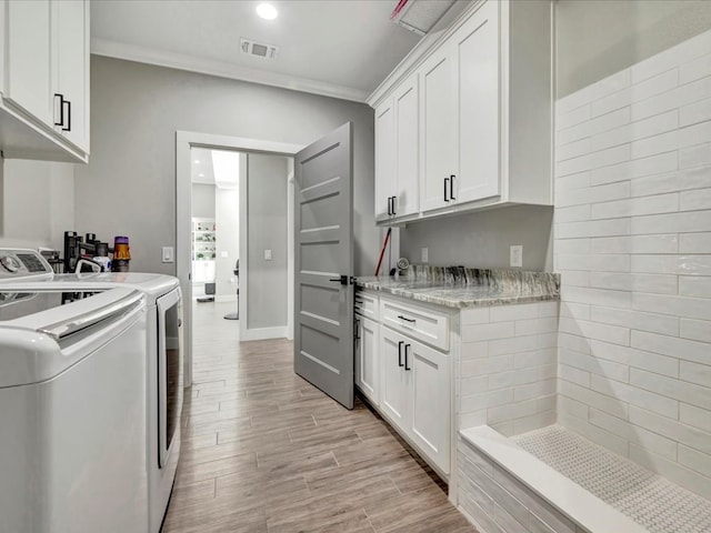 387 Cc Rd, Diboll, TX 75941 - laundry area featuring washing machine and dryer, crown molding, cabinet space, light wood finished floors, and recessed lighting