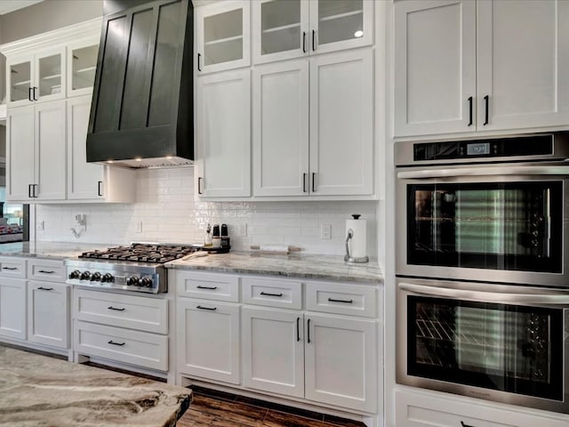 387 Cc Rd, Diboll, TX 75941 - kitchen with appliances with stainless steel finishes, range hood, white cabinetry, and decorative backsplash