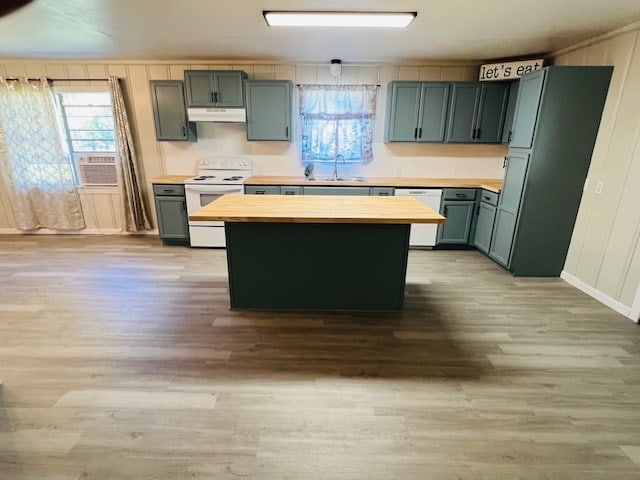 kitchen featuring sink, white appliances, butcher block counters, a center island, and light hardwood / wood-style floors