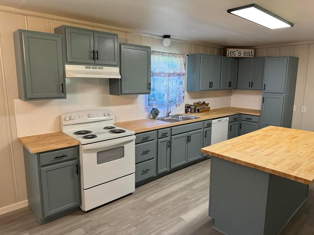 kitchen with butcher block counters, sink, white appliances, and light hardwood / wood-style flooring