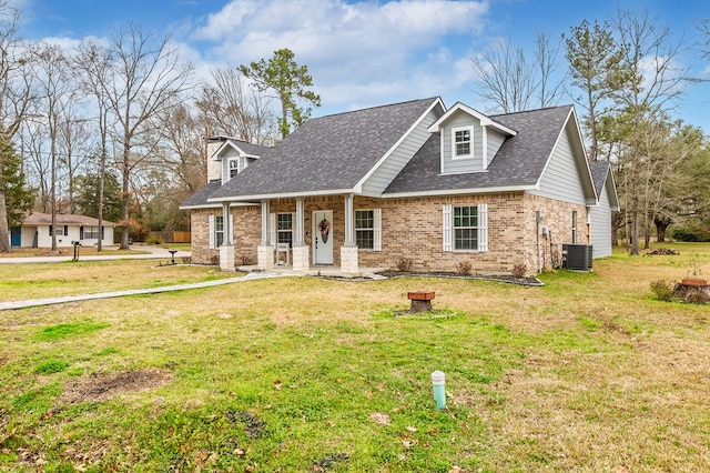 view of front of home with brick siding, a front lawn, a shingled roof, and central air condition unit