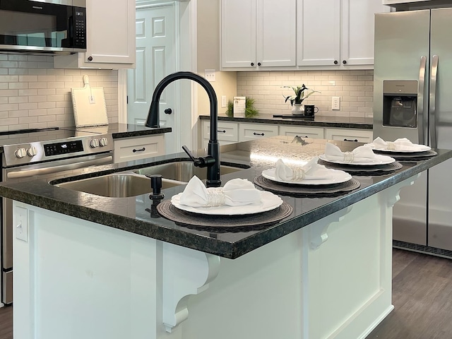 kitchen featuring a sink, decorative backsplash, white cabinets, and stainless steel appliances