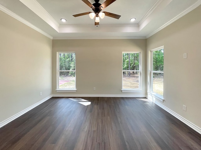empty room featuring a raised ceiling, baseboards, a ceiling fan, and dark wood-style floors