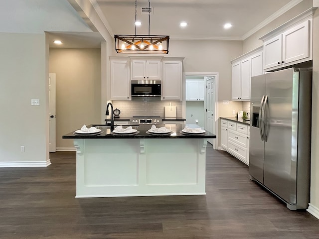 kitchen featuring stainless steel appliances, dark countertops, visible vents, and a sink