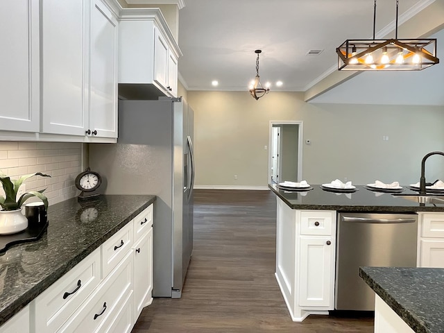 kitchen with white cabinets, appliances with stainless steel finishes, dark wood-style floors, and tasteful backsplash