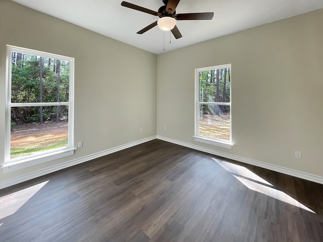 spare room featuring baseboards, a ceiling fan, and dark wood-style floors